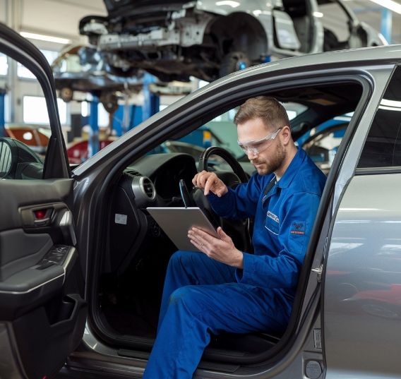 Auto-Mechanic-doing-Factory-Scheduled-Maintenance-at-Collision-Boss